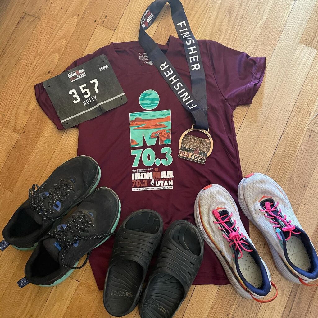 An Ironman jersey, shoes, and medal displayed
